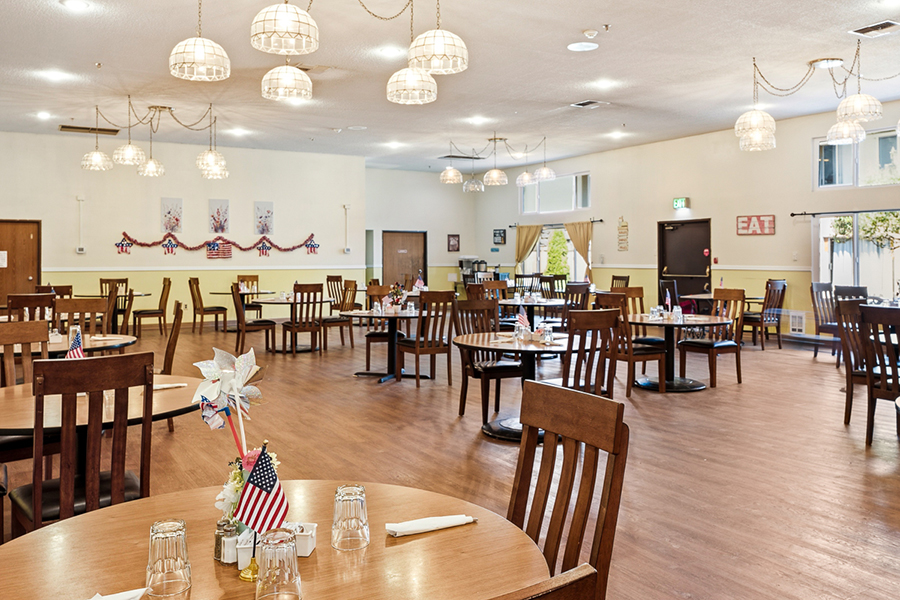 Bright, empty dining area with wooden tables and chairs.