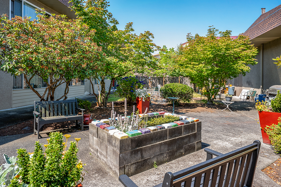 Lush garden space with seating and colorful flower beds.