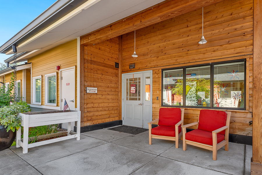 Entrance with red chairs and wooden walls. Bright atmosphere.