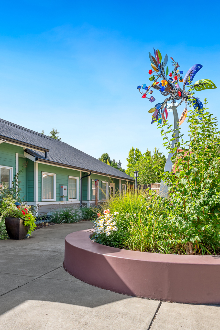 Colorful outdoor area with vibrant plants and artistic sculpture.