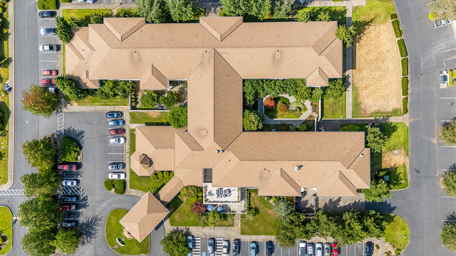 Aerial view of a building complex with surrounding parking lot.
