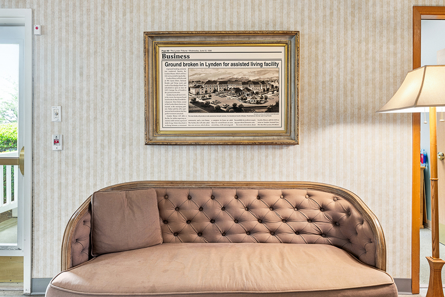 Cozy seating area with framed newspaper about assisted living.