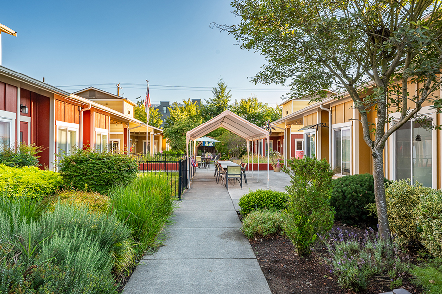 Colorful buildings with landscaped walkways and outdoor seating area.