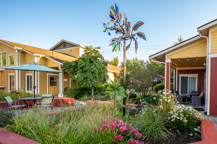 Colorful garden with playful sculpture and cozy sitting areas.