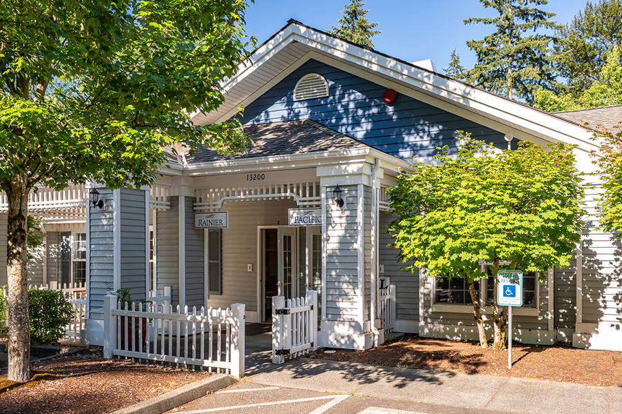 Charming building with trees and white picket fence.