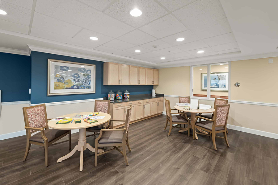 Bright, inviting room with tables and wooden cabinetry.