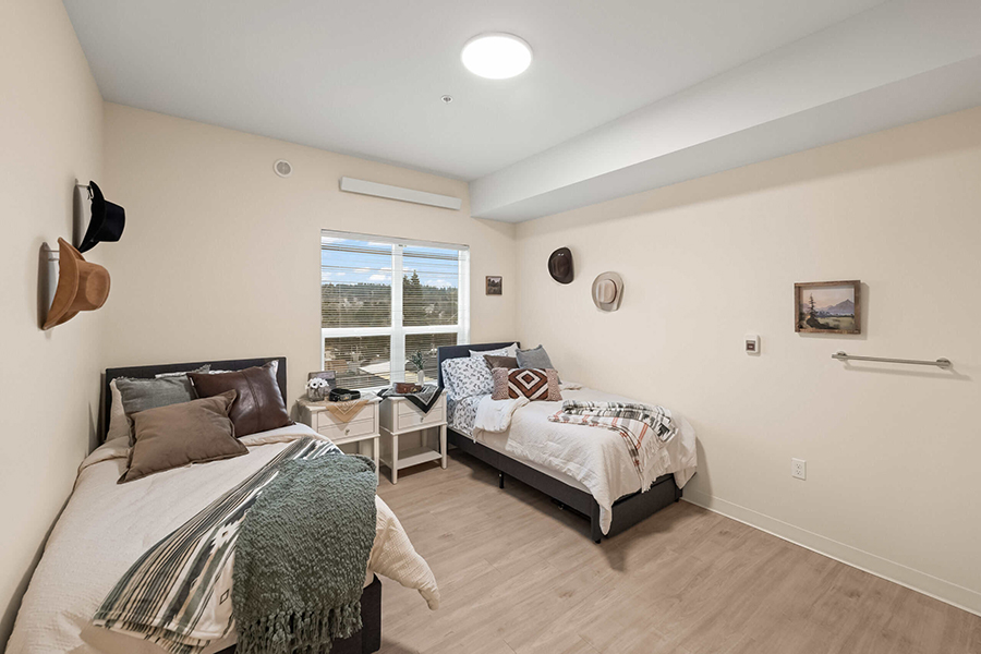 Cozy shared bedroom with two beds and natural light.