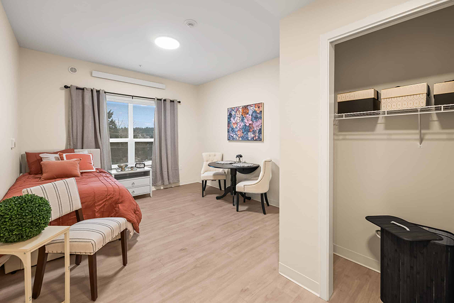 Cozy, modern room with bed, dining area, and closet.