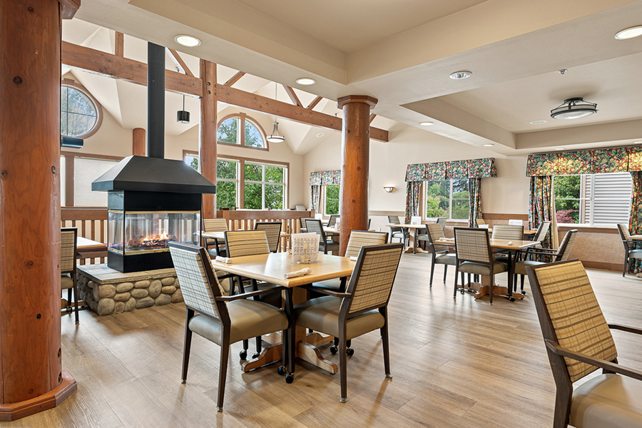 Cozy dining area with wooden beams and fireplace.