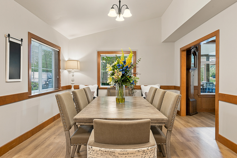 Modern dining room with a floral centerpiece and natural light.