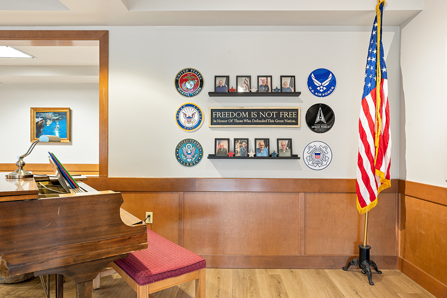 Wall display honoring military service and freedom, with flags.