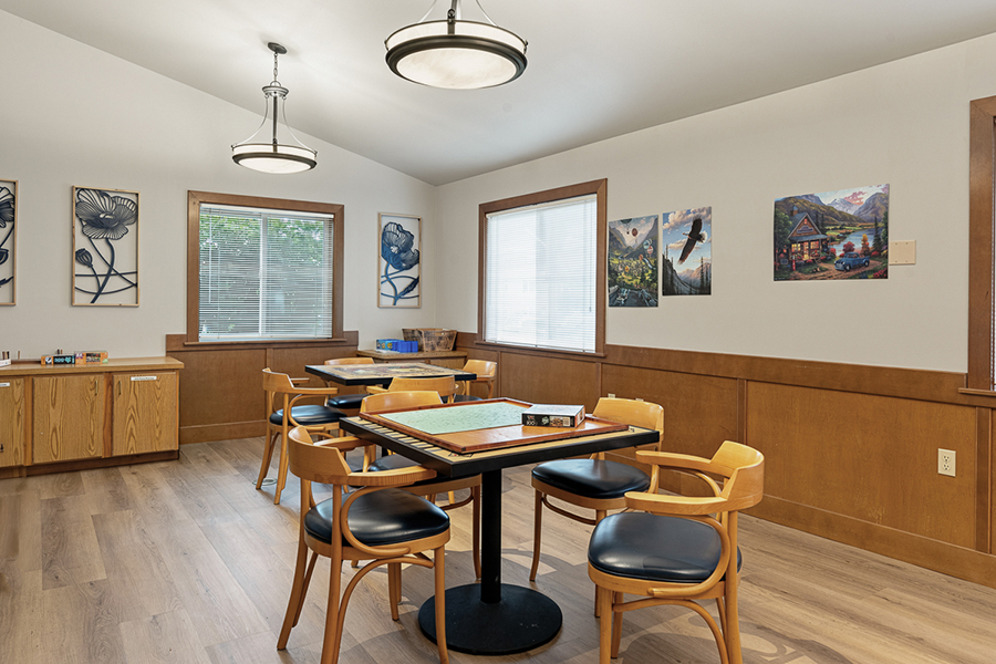 Bright, inviting room with tables and scenic artwork.