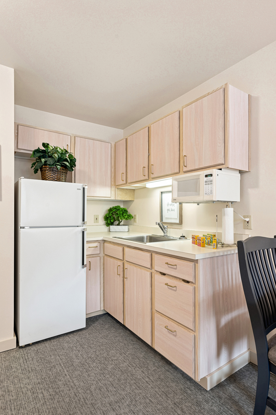 Modern kitchen with light wood cabinets and basic appliances.