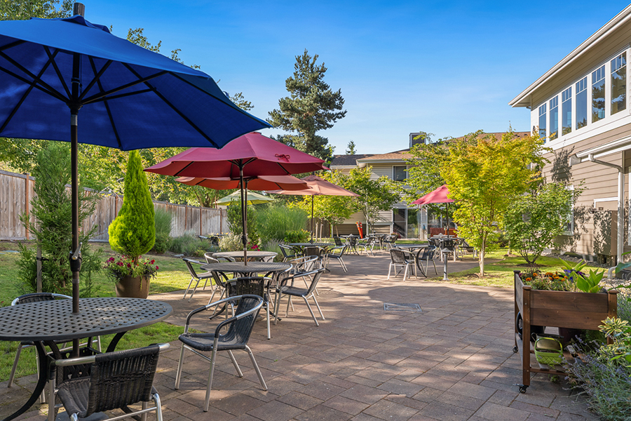 Outdoor seating area with umbrellas and lush greenery.