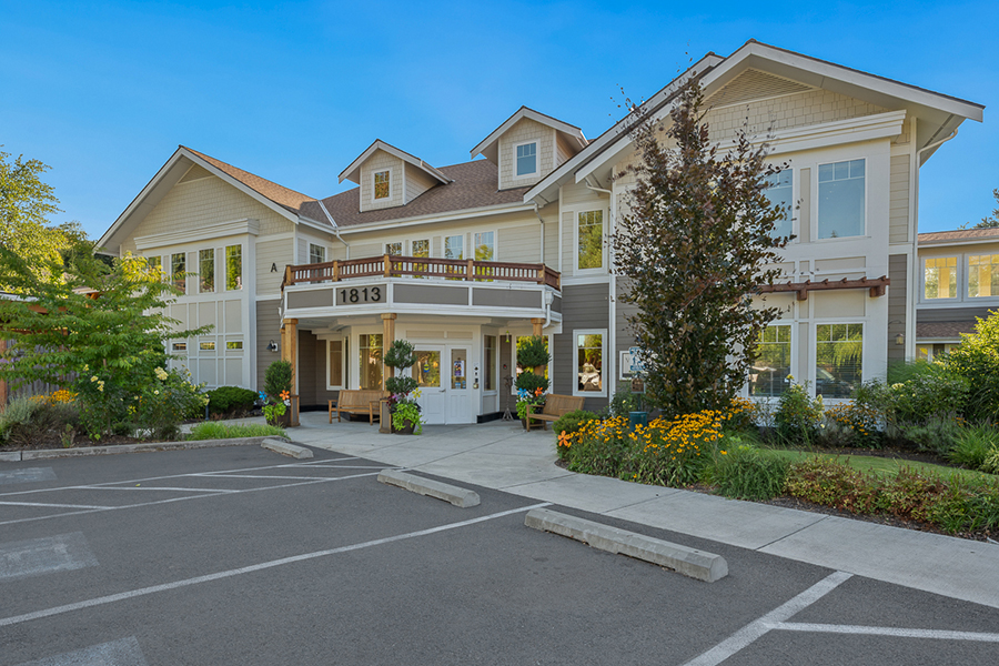 Charming building with landscaped entrance and parking area.