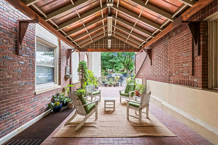 Covered outdoor seating area with plants and a view.
