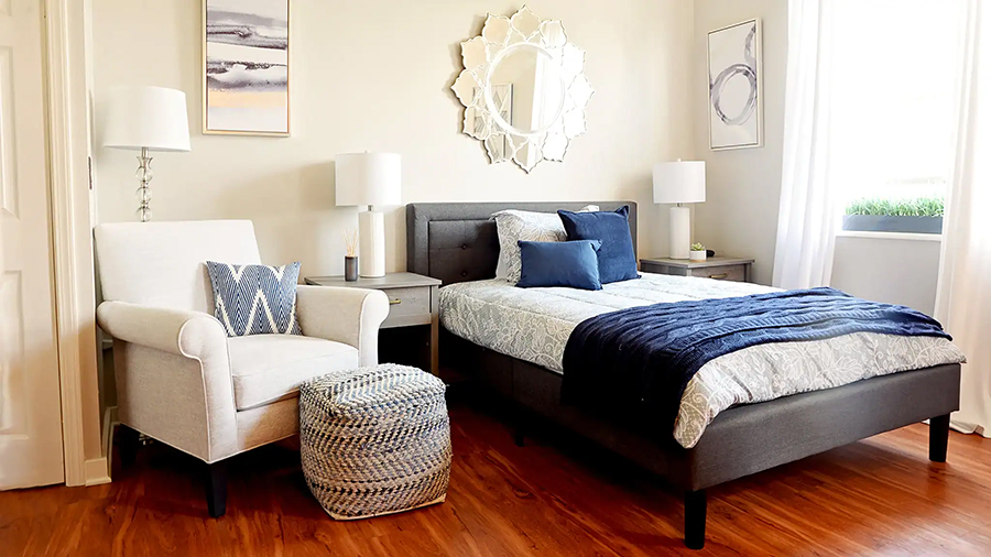 Cozy bedroom with bed, armchair, and decorative elements.