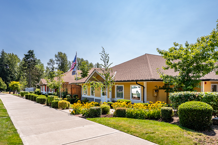 Colorful building with flowers, trees, and a clear blue sky.