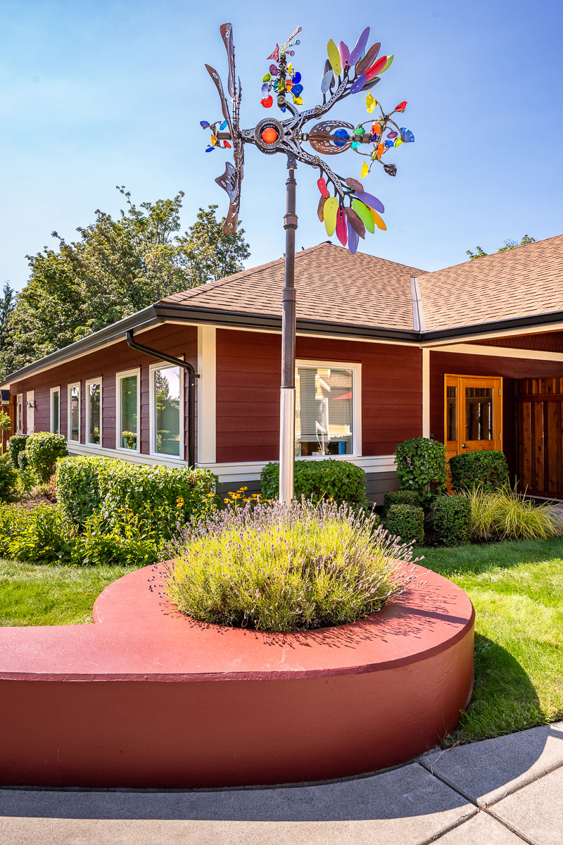 Colorful art installation near a welcoming, landscaped home.