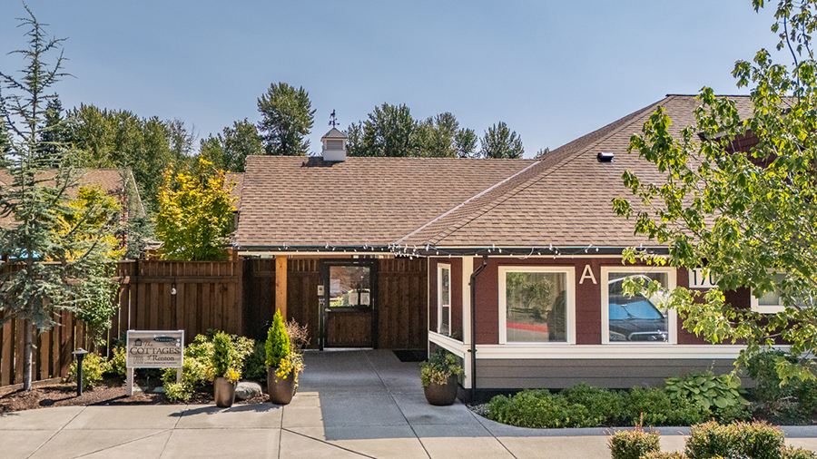 Cottage-style building with landscaped entrance and clear sky.