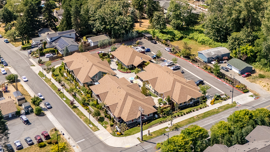 Aerial view of residential buildings and surrounding landscape.