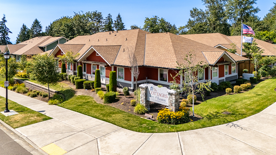 Cottages in a landscaped area with clear blue sky.