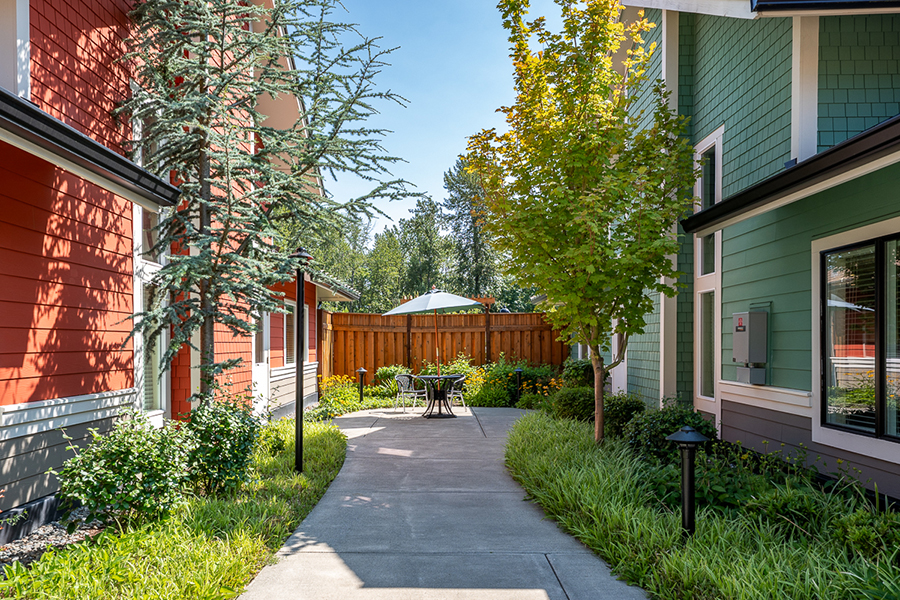 Colorful buildings with a garden pathway and seating area.