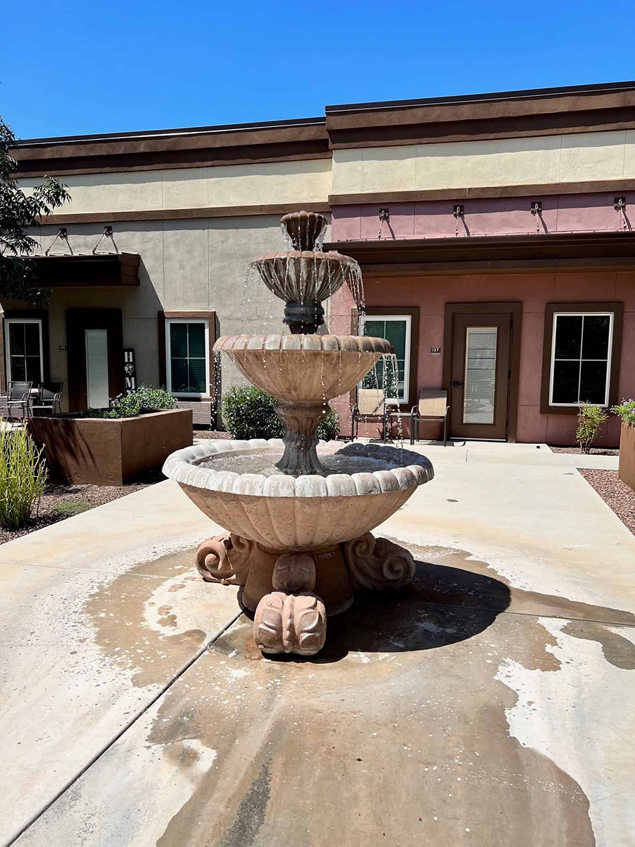 Decorative fountain with flowing water in a courtyard.