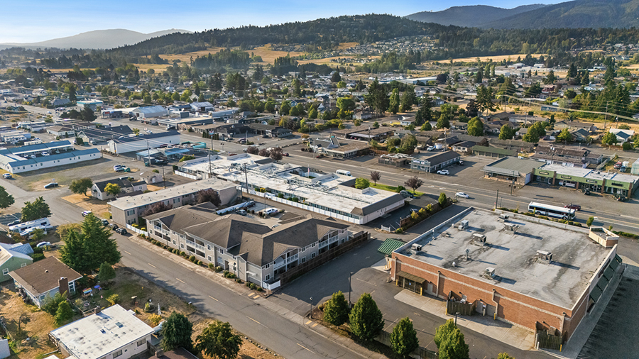 Aerial view of a small town with businesses and mountains.