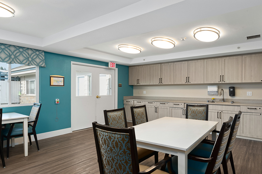 Bright, modern communal space with kitchen and dining tables.