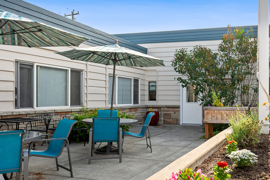 Outdoor seating area with umbrellas and greenery.