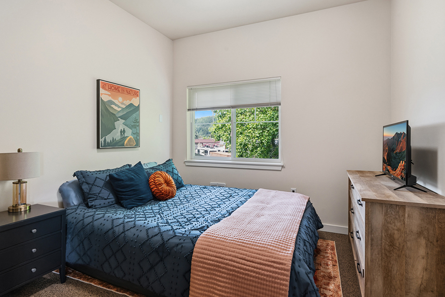 Cozy bedroom with a view, warm tones and decor.