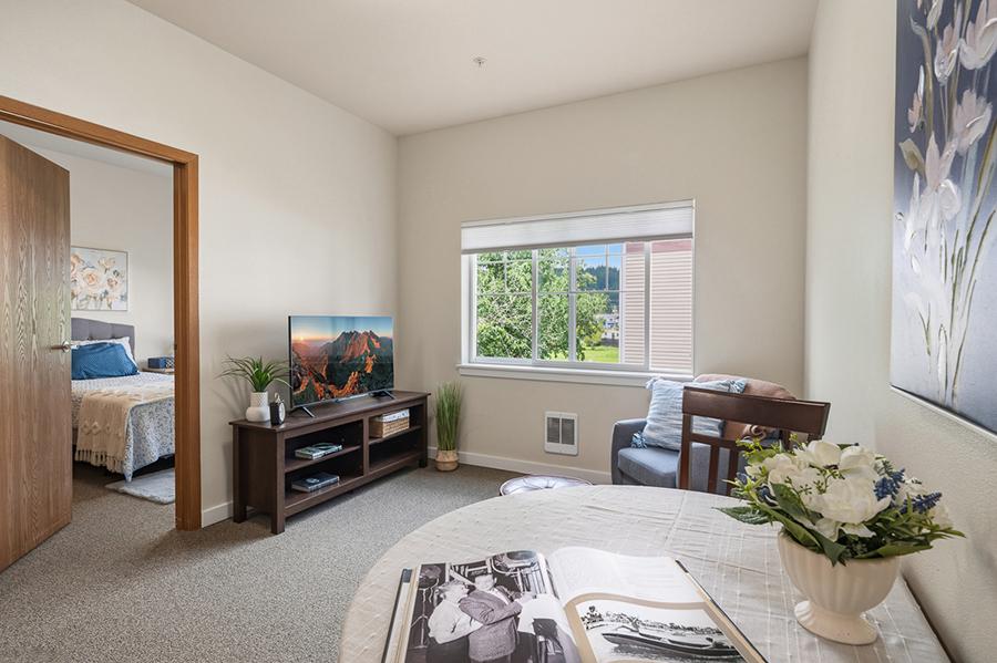 Cozy living room with bedroom view, plants, and decor.