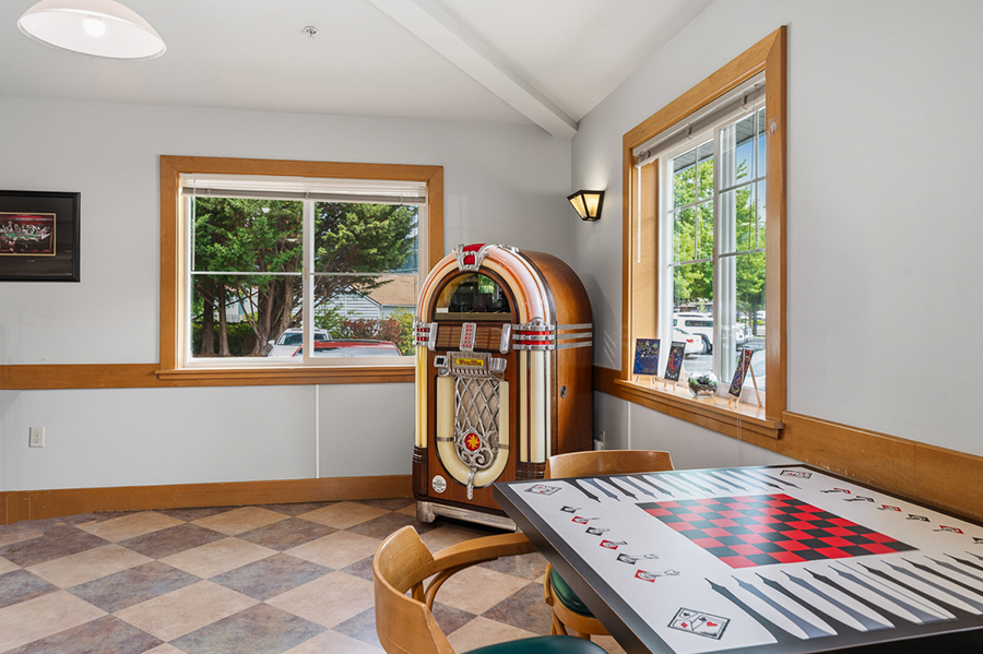 Retro jukebox in a cozy room with a checkerboard table.