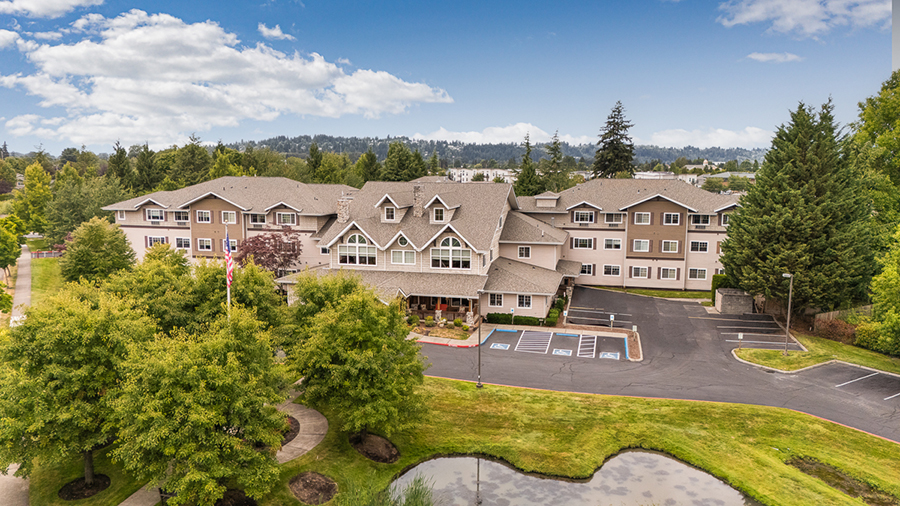 Residential building surrounded by trees and landscaping.