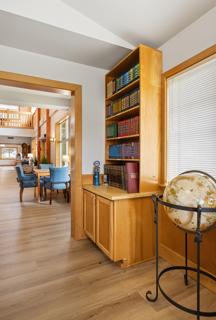 Cozy interior with bookshelves and globe, inviting atmosphere.