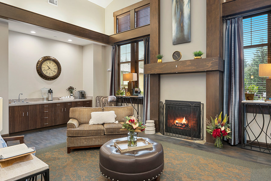 Cozy living room with fireplace, plants, and comfortable seating.