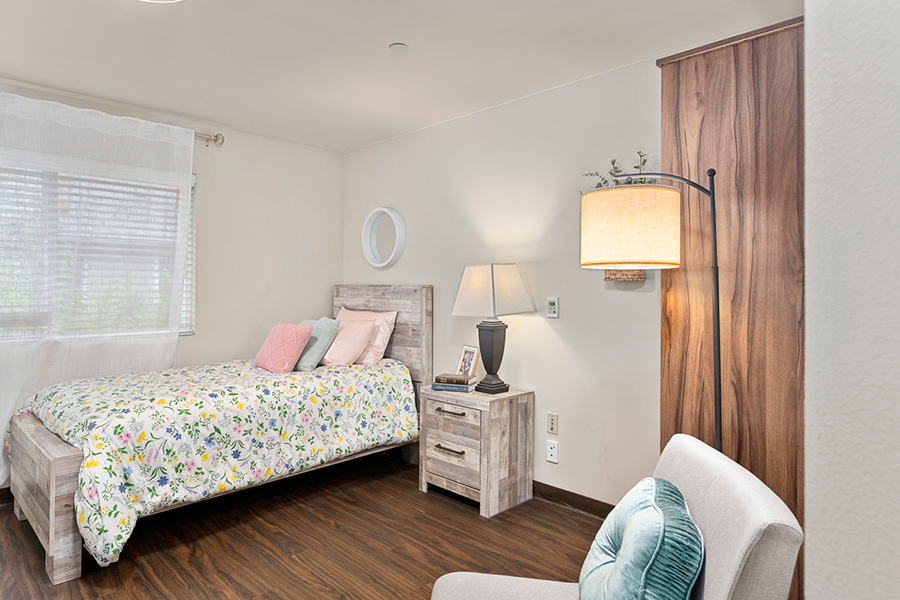 Cozy bedroom with floral bedding and warm lighting.