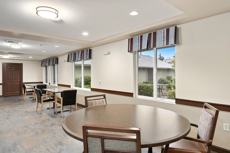 Bright, spacious room with tables and chairs, natural light.