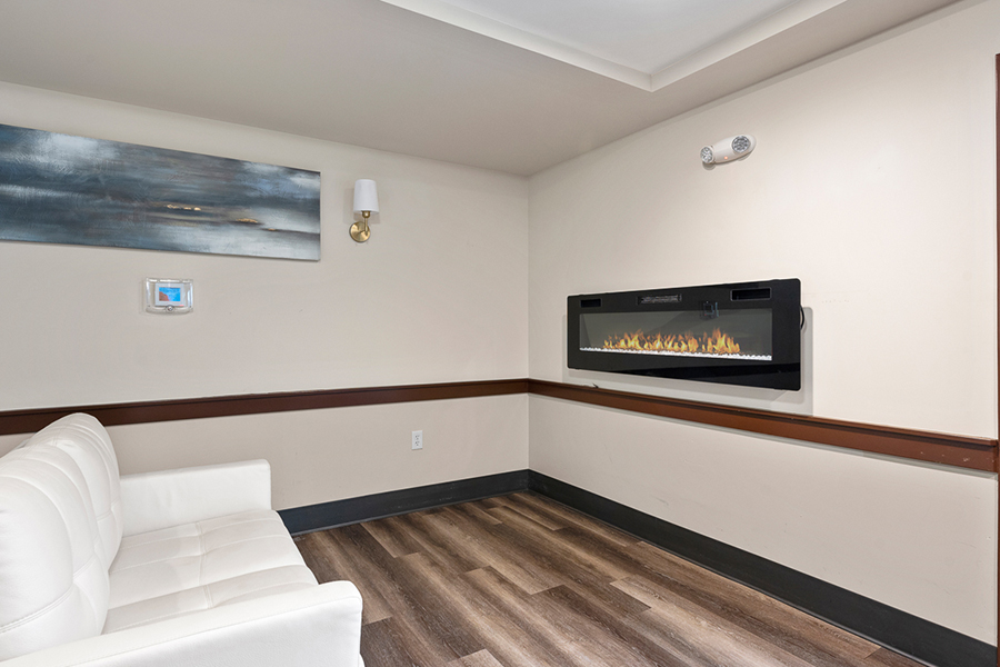 Modern room with sleek electric fireplace and white sofa.