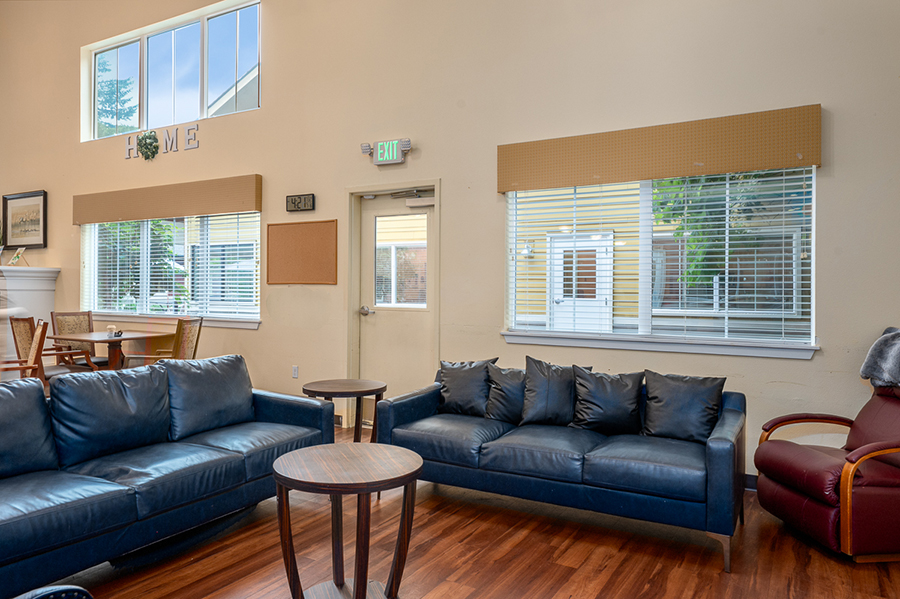 Cozy living room with couches, table, and large windows.