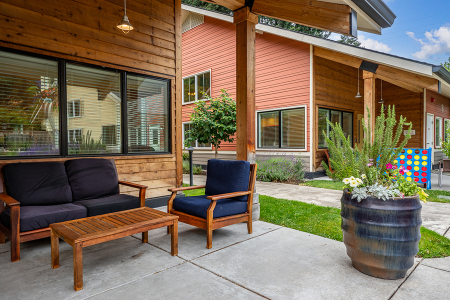 Comfortable outdoor seating with colorful plant arrangements nearby.