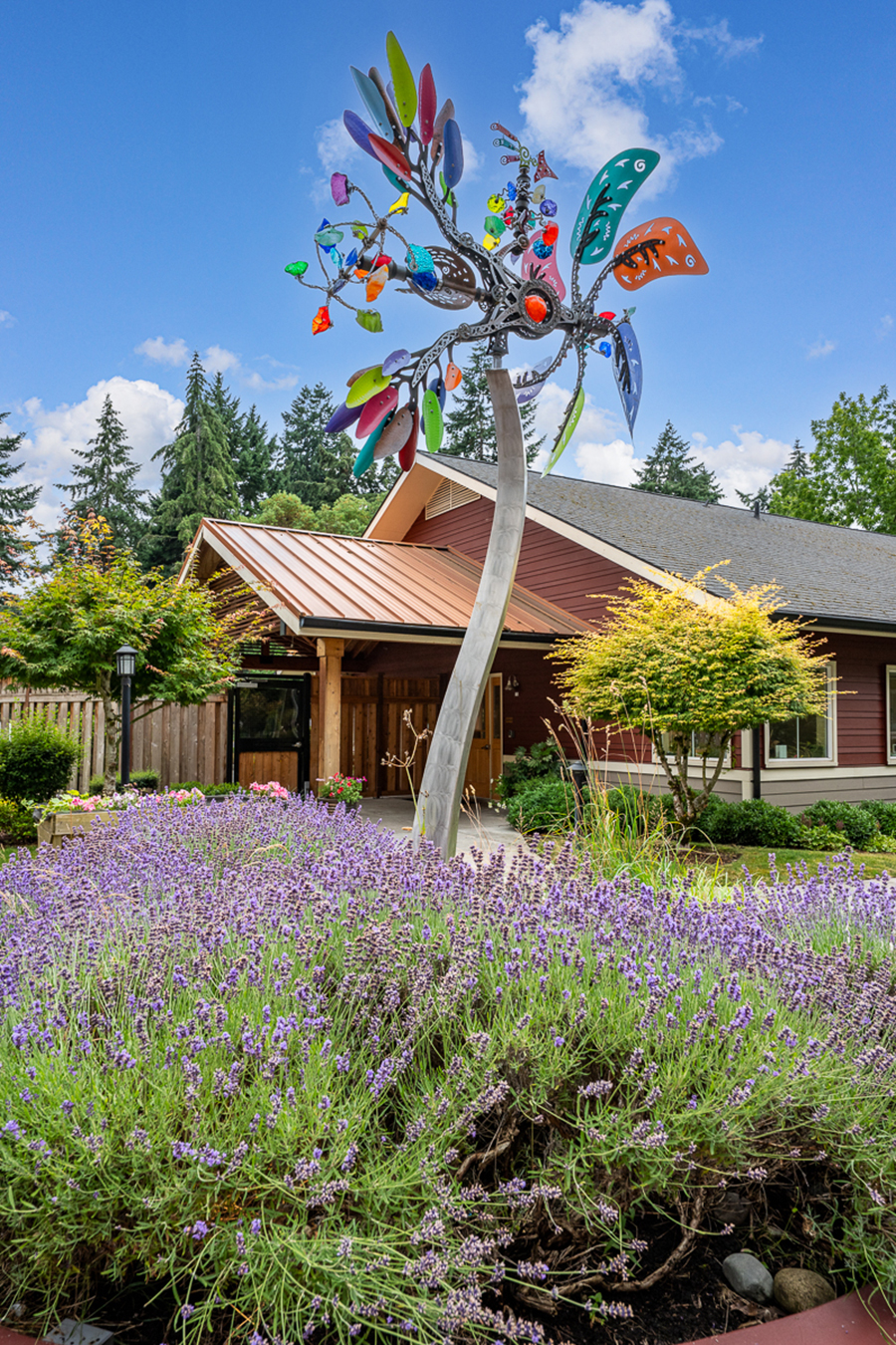Colorful metal tree sculpture in a lavender garden.
