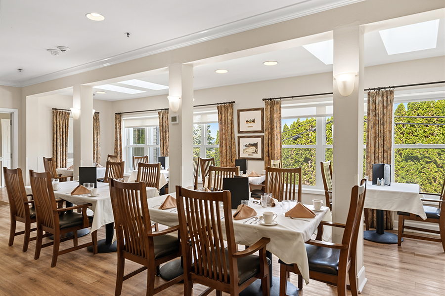 Bright dining area with wooden furniture and large windows.