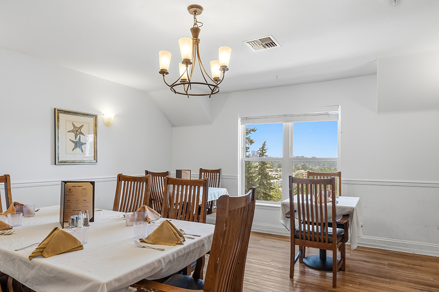 Bright dining room with wooden tables and scenic window view.