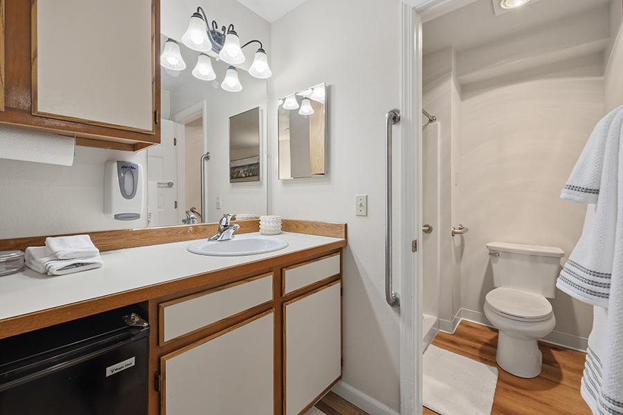 Clean bathroom with sink, toilet, and shower area.