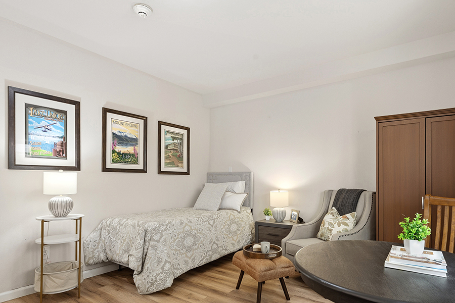 Cozy bedroom with artwork, furniture, and warm lighting.