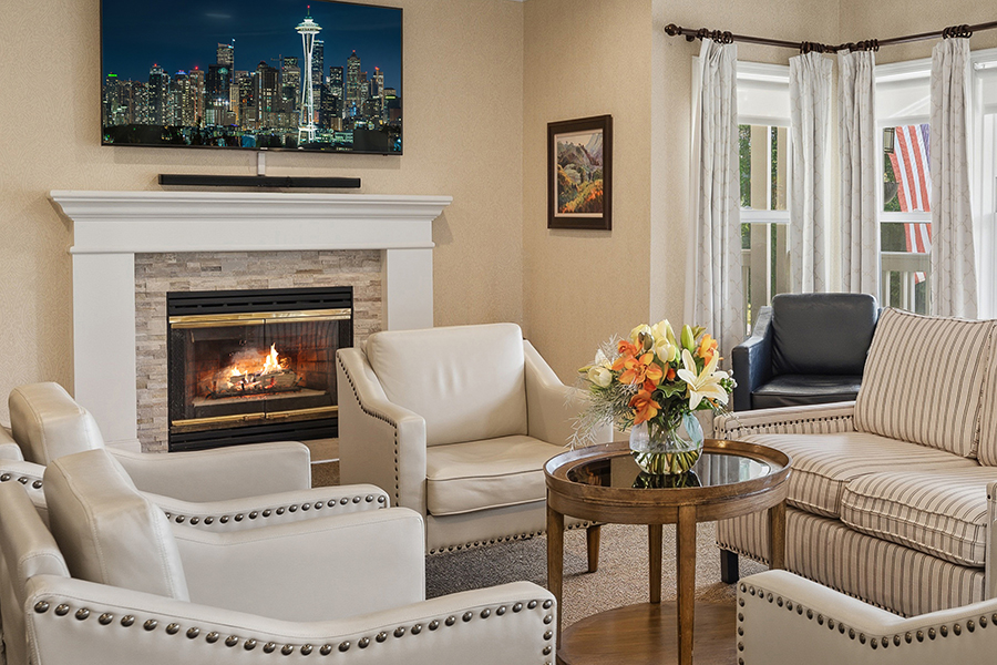 Cozy living room with fireplace, TV, and flower arrangement.