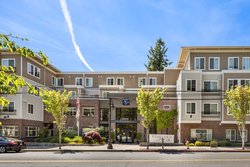 Modern apartment building with trees and clear blue sky.
