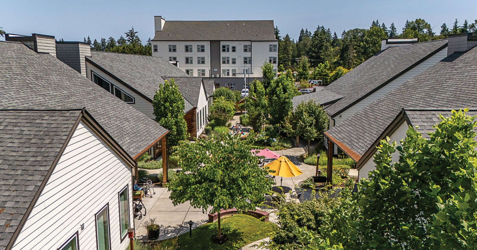 Residential area with trees, pathways, and colorful outdoor seating.